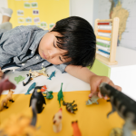 Child engaging in imaginative play with animal toys during an ABA therapy session, illustrating individualized, creative, and child-led learning.
