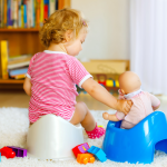 A smiling parent and child celebrating a potty training milestone together, with a reward chart and bathroom in the background—representing positive reinforcement through ABA therapy.