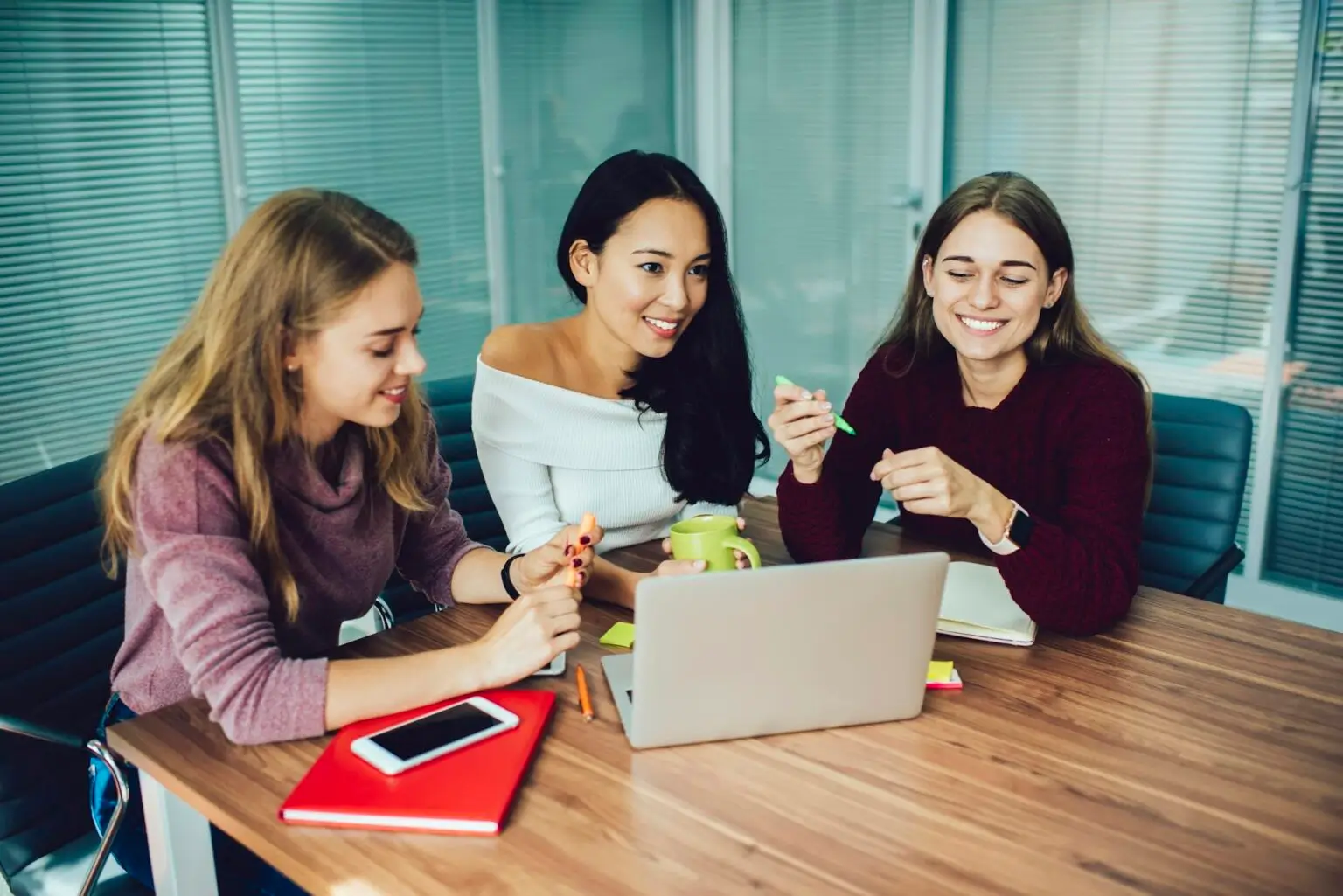Three young women practicing social interaction skills during ABA therapy group session at The Buddy Center in Greenville SC